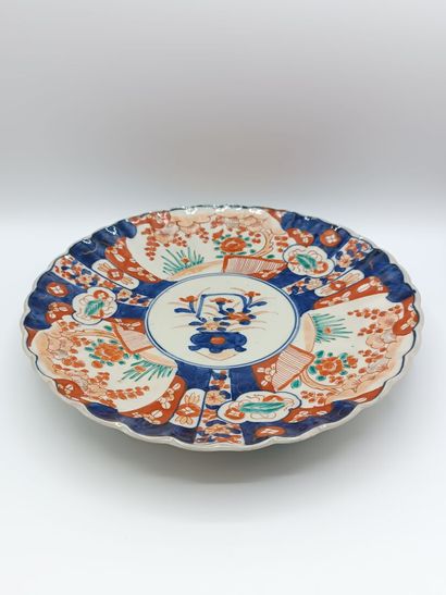 IMARI. 
Plat en porcelaine polychrome à bords...