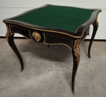 Table à jeux en bois noirci à plateau portefeuille.
Décor...