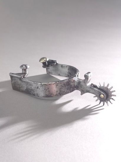 Éperon à molette en métal. 
Décor d'une frise...
