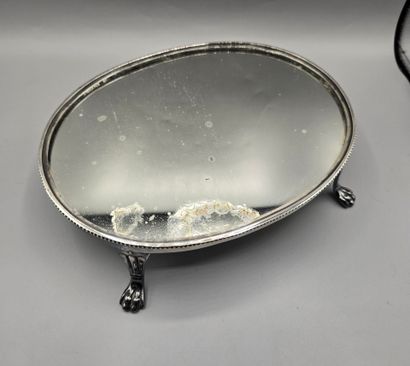 Oval silver-plated metal display tray resting...
