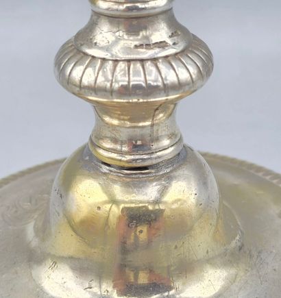 A silver-plated bronze candlestick with a...