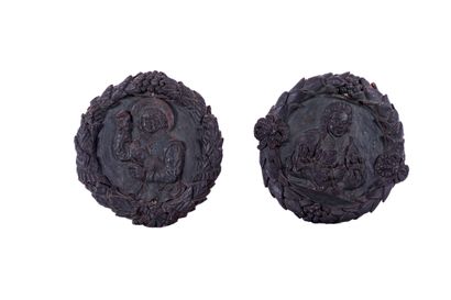 Two terracotta medallions representing jovial...