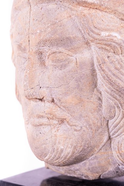 Man's head in marble stone. Wearing a cap...