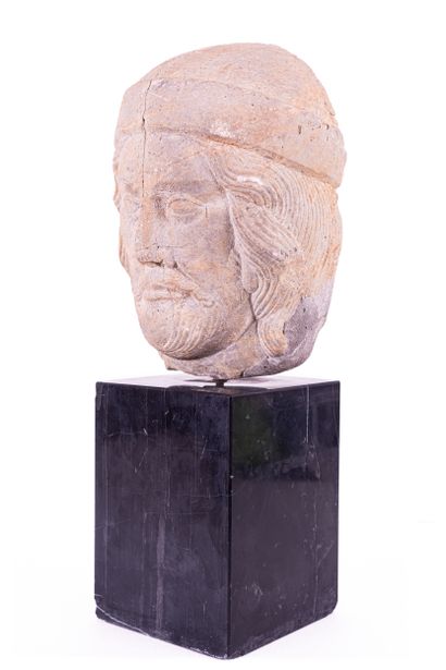Man's head in marble stone. Wearing a cap...