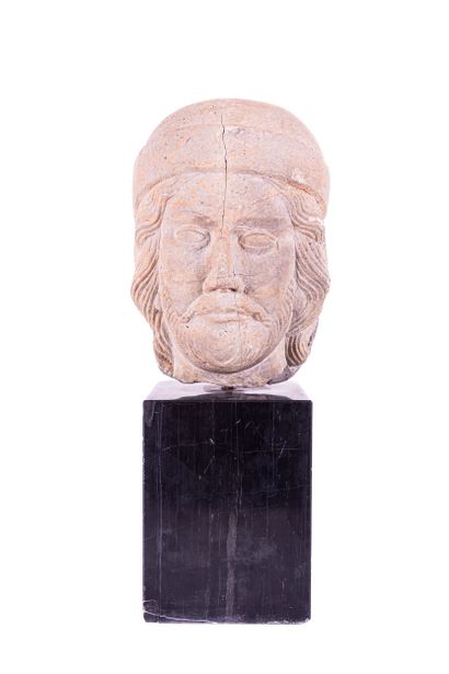 Man's head in marble stone. Wearing a cap...