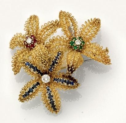 Broche à décor de trois fleurs or guilloché...