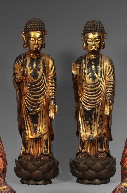 Deux Bouddha en bois laqué rouge et or. Debout,...