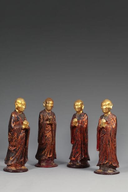 Quatre prieurs en bois laqué rouge et or....
