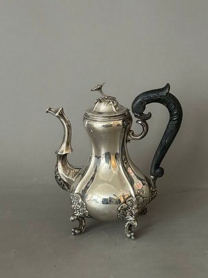 Four-legged silver coffee pot. Curved blackened...
