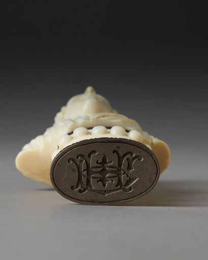 *A finely carved ivory seal featuring a bust...