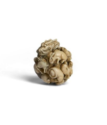 *Ivory ball-shaped netsuke with richly carved...