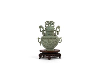 Green hardstone vase presented on a carved...