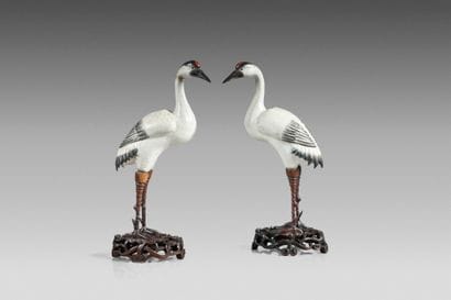 Pair of polychrome ceramic cranes, with carved...