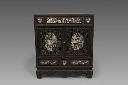 A small cabinet made of exotic wood, with...