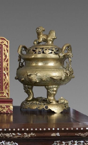 A two-handled, tripod incense burner made...