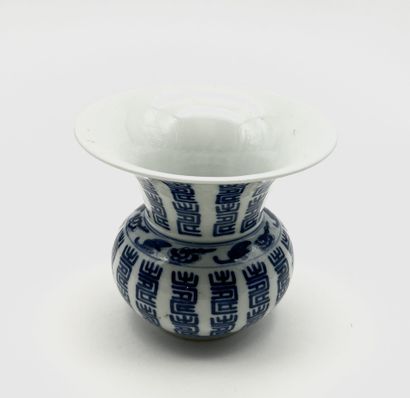 A spouted bowl with a flared neck, made of...
