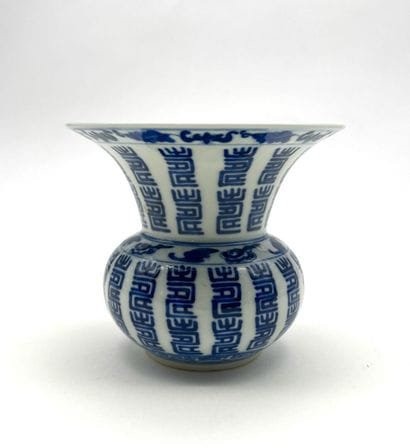 A spouted bowl with a flared neck, made of...