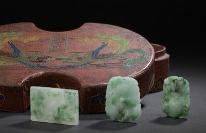 Three jadeite pendants and their lacquered...