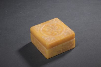Covered box and its two small stamps in orange-yellow...