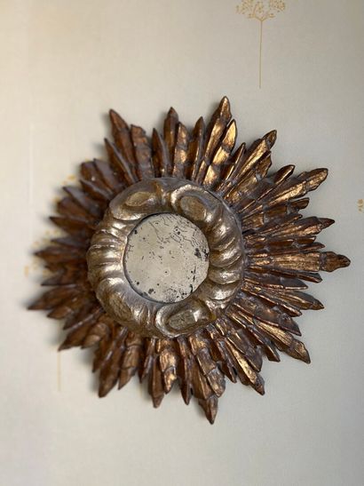 Petit miroir rond en bois doré à décor rayonnant,...