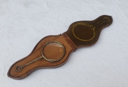 
Leather case containing a silver magnifying...