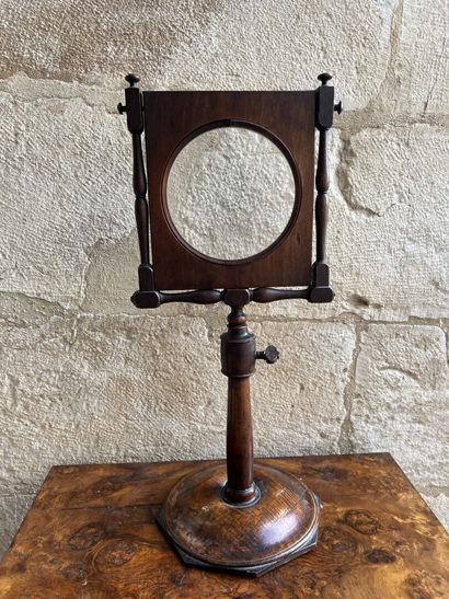Magnifying glass on a natural wood pedestal,...