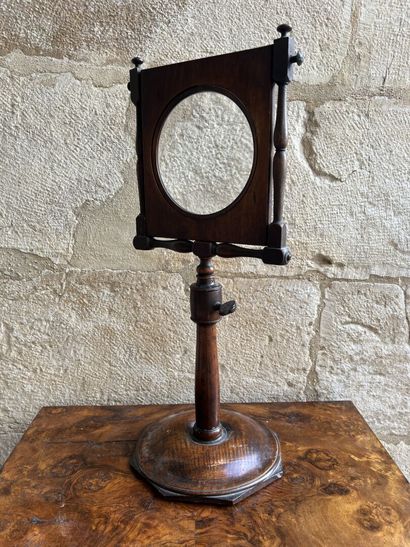 Magnifying glass on a natural wood pedestal,...