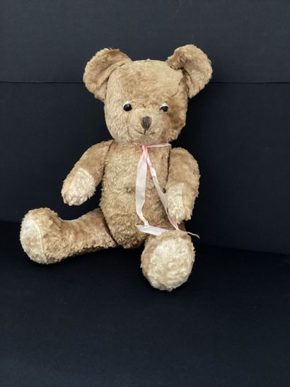 OURSON en peluche articulé, ruban rose.
H...