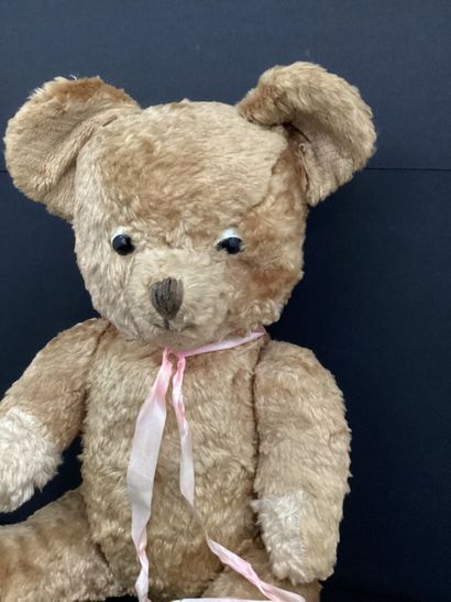 OURSON en peluche articulé, ruban rose.
H...