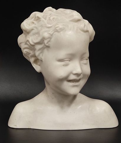 A wax bust of a laughing child on a wooden...