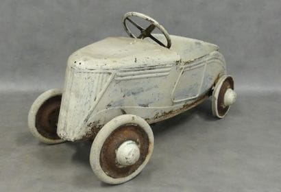 A white-painted sheet metal pedal car 
Oxidation...