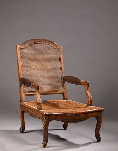 Fauteuil bas canné en bois mouluré sculpté...