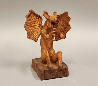 Petit diable tenant un volant, en bois sculpté...