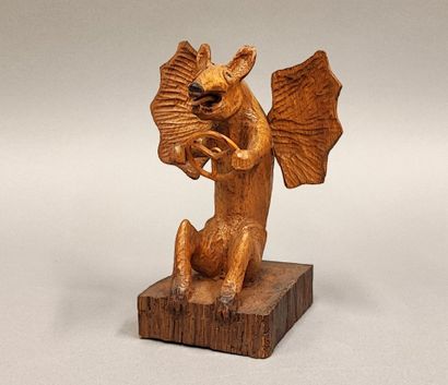 Petit diable tenant un volant, en bois sculpté...