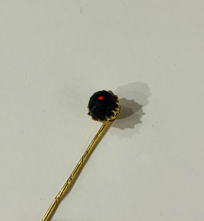 Tie pin set with a faceted garnet in 14K...