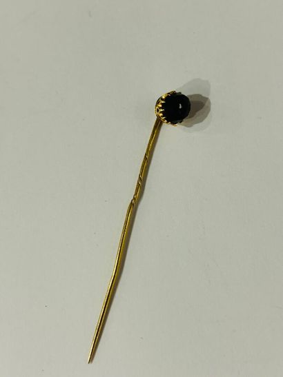 Tie pin set with a faceted garnet in 14K...