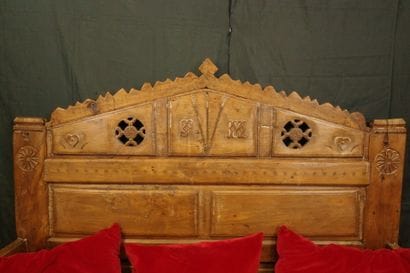 Daybed with a solid, crenellated headboard...