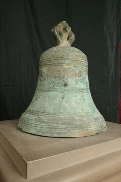 Large bronze bell decorated with angel heads...