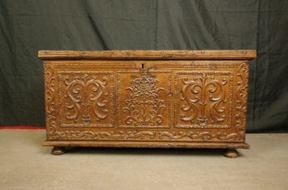 Natural wood cabinet with a carved three-panel...