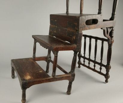 A four-step stool-style chair made of dark...