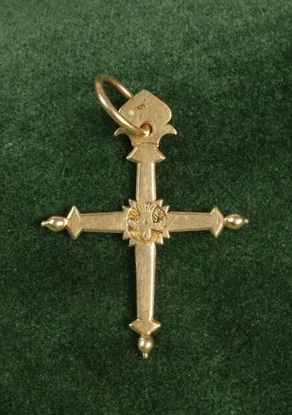 A flat 750 gold cross featuring a flower...