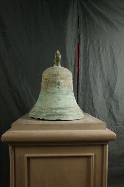 Large bronze bell decorated with angel heads...