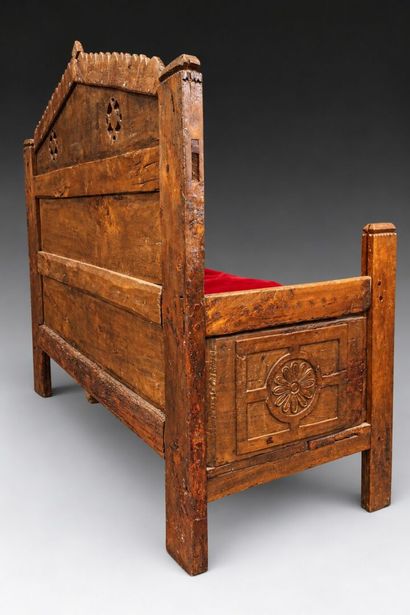 Daybed with a solid, crenellated headboard...