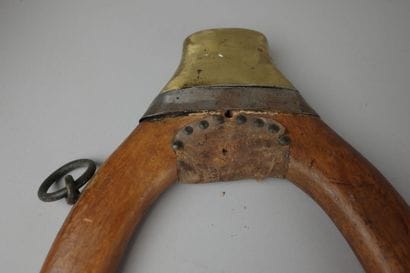 Wooden, brass, and leather donkey yoke with...