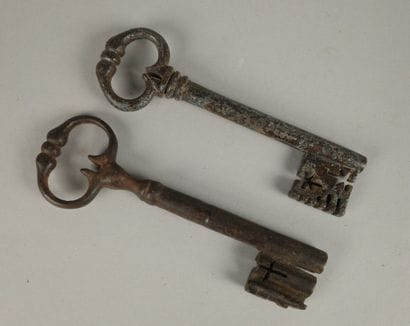 Two wrought-iron keys, one with an oval ring...