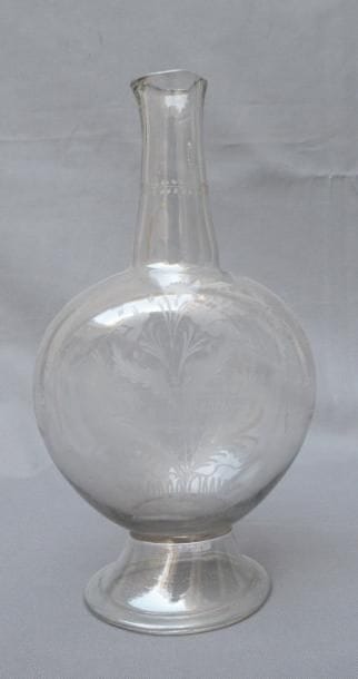 Grande bouteille en verre sur piédouche gravé...