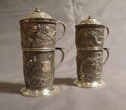 Paire de tasses et passe-thé en argent repoussé...