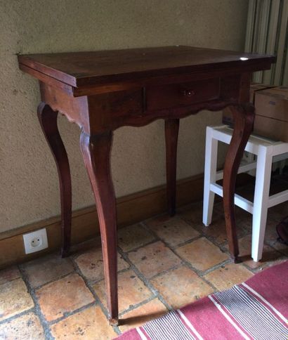 Table à jeu en noyer. Le plateau dépliant,...