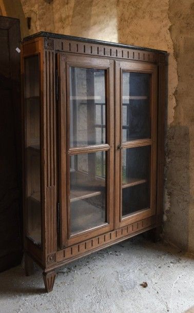 Vitrine en noyer Louis XVI. Elle ouvre à...