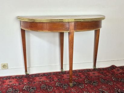 Table demi lune en merisier du XIXe siècle.

Elle...